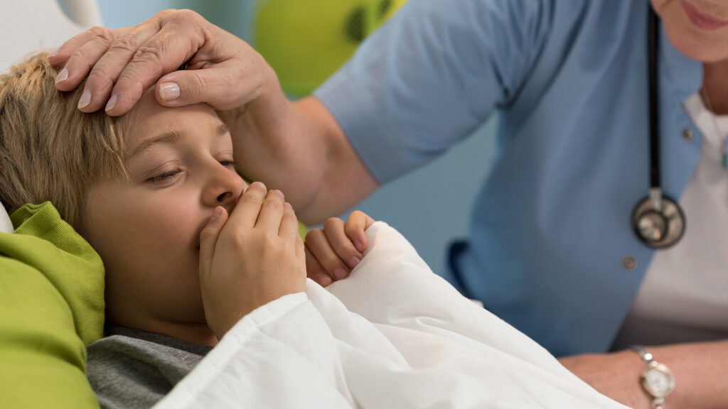 Enfant malade avec toux au lit d'hôpital.