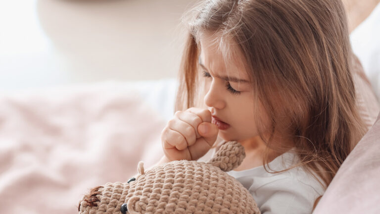 Jeune fille toussant dans sa main.