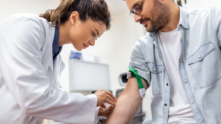 Médecin effectuant un prélèvement sanguin sur un patient pour un bilan de santé.