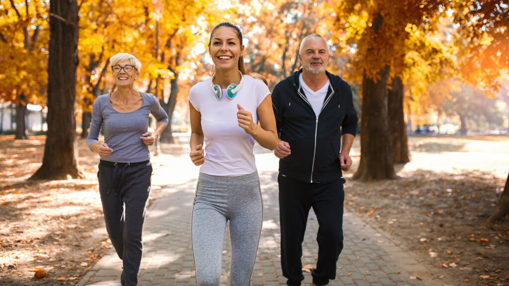 Groupe de personnes âgées faisant du jogging dans un parc, symbolisant un mode de vie actif.