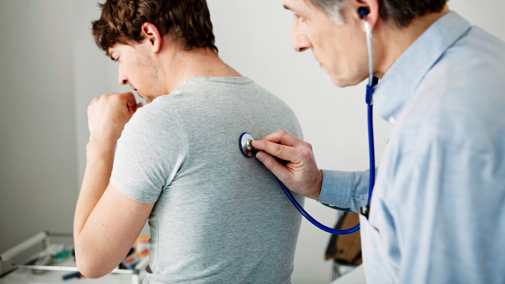 Un professionnel de la santé effectuant une auscultation pulmonaire sur un patient.