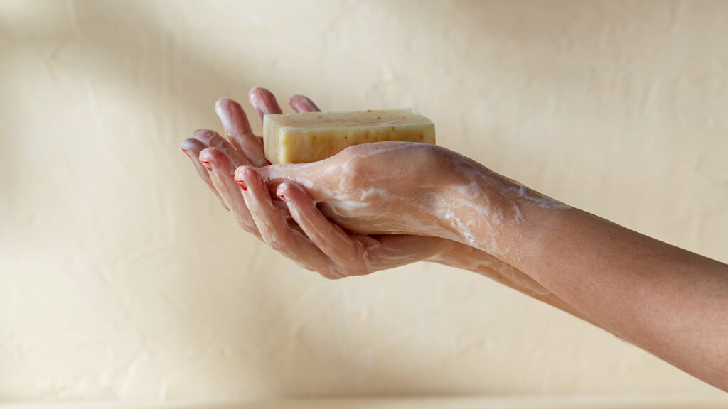 Mains se lavant avec un savon antiseptique naturel.