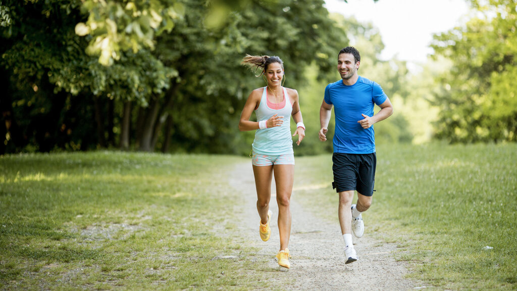 Deux personnes faisant du jogging dans un parc, illustrant l'importance de l'exercice pour les individus atteints d'asthme.