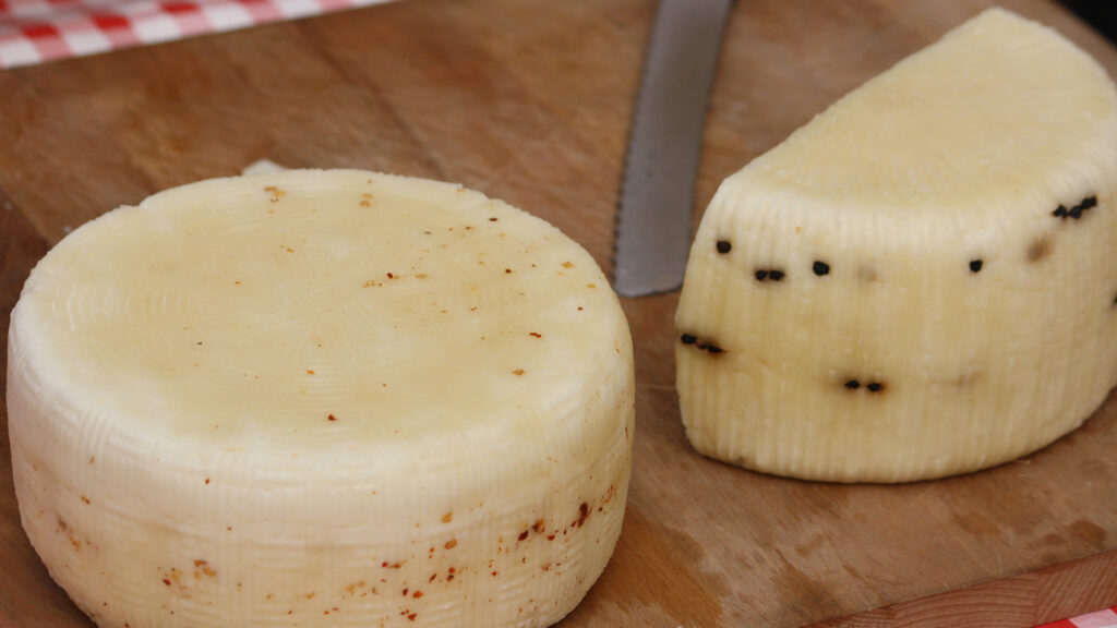 Fromages pasteurisés avec des graines de poivre sur une table en bois