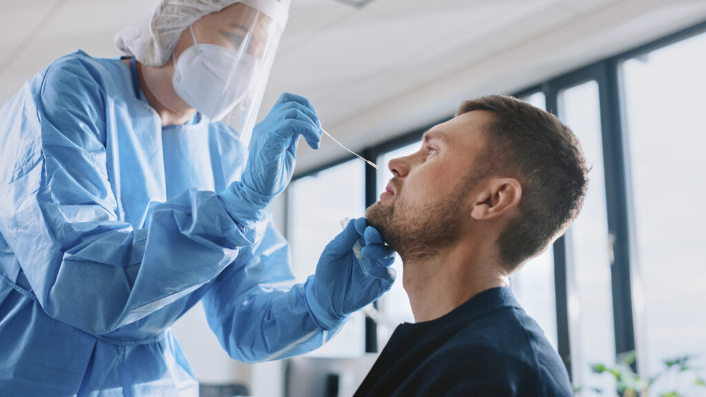 Professionnel de santé effectuant un test COVID-19 par prélèvement nasal sur un patient.