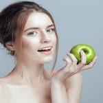Une femme mange une pomme verte
